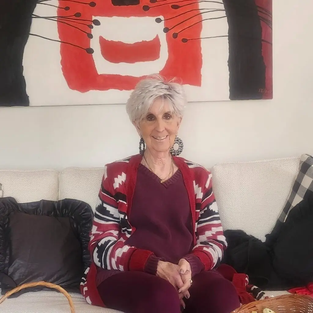 senior woman sitting on a couch looking at the camera