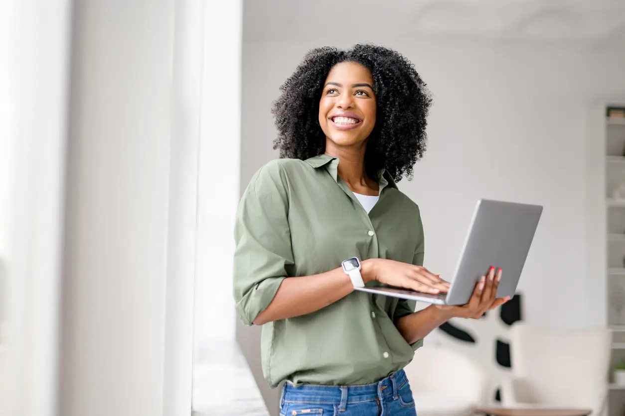 Radiant African-American woman casually handles laptop