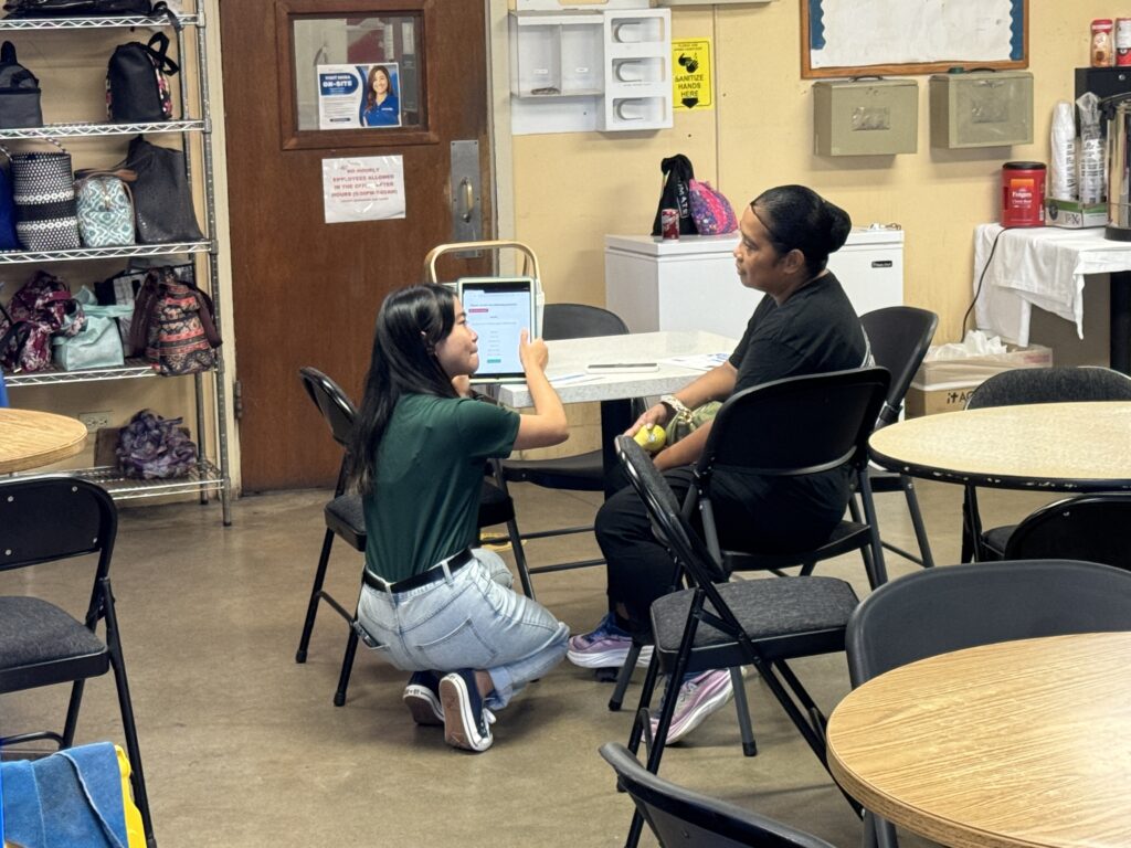 Community health worker helping a client using a computer.